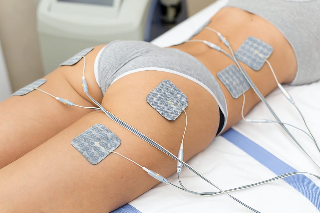 Beautiful woman getting electrostimulation therapy, anti-cellulite and anti-fat therapy on her tight